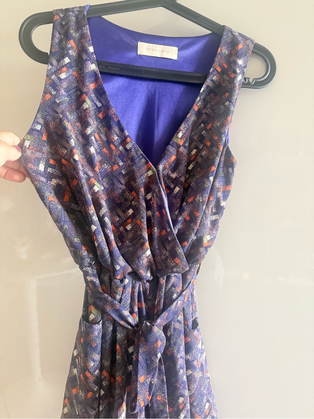 Staccato sleeveless wrap dress features a vibrant color romper